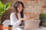 Cambios en las listas de oferta laboral de Nueva Zelanda. Chica joven sonriendo delante del ordenador