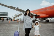 Nueva regulación migratoria para reunificar a las familias de los titulares de visa de trabajo de Nueva Zelanda. Mamá embarazada viajando con su hija pequeña, viajando a Nueva Zelanda. Avión de fondo.
